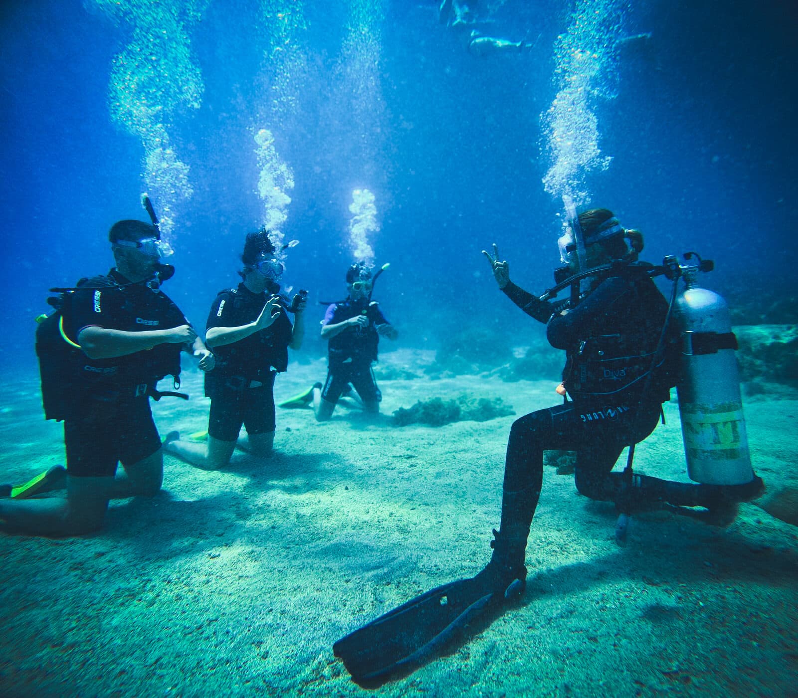 Dive course students practising skills underwater with their instructors in Kaş