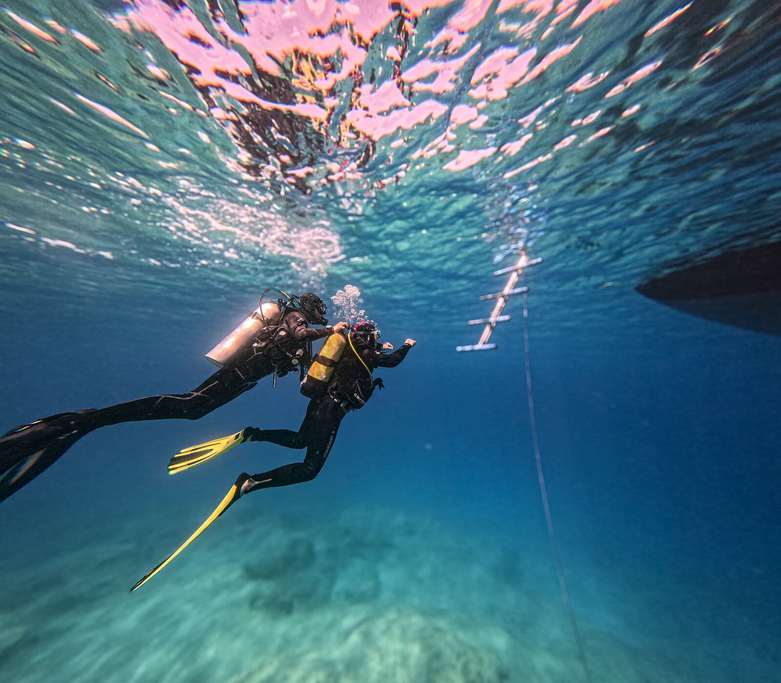 Two divers descending into the blue in Kaş